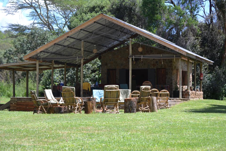 Outdoor chairs and tables on the lawn beside the dining veranda.