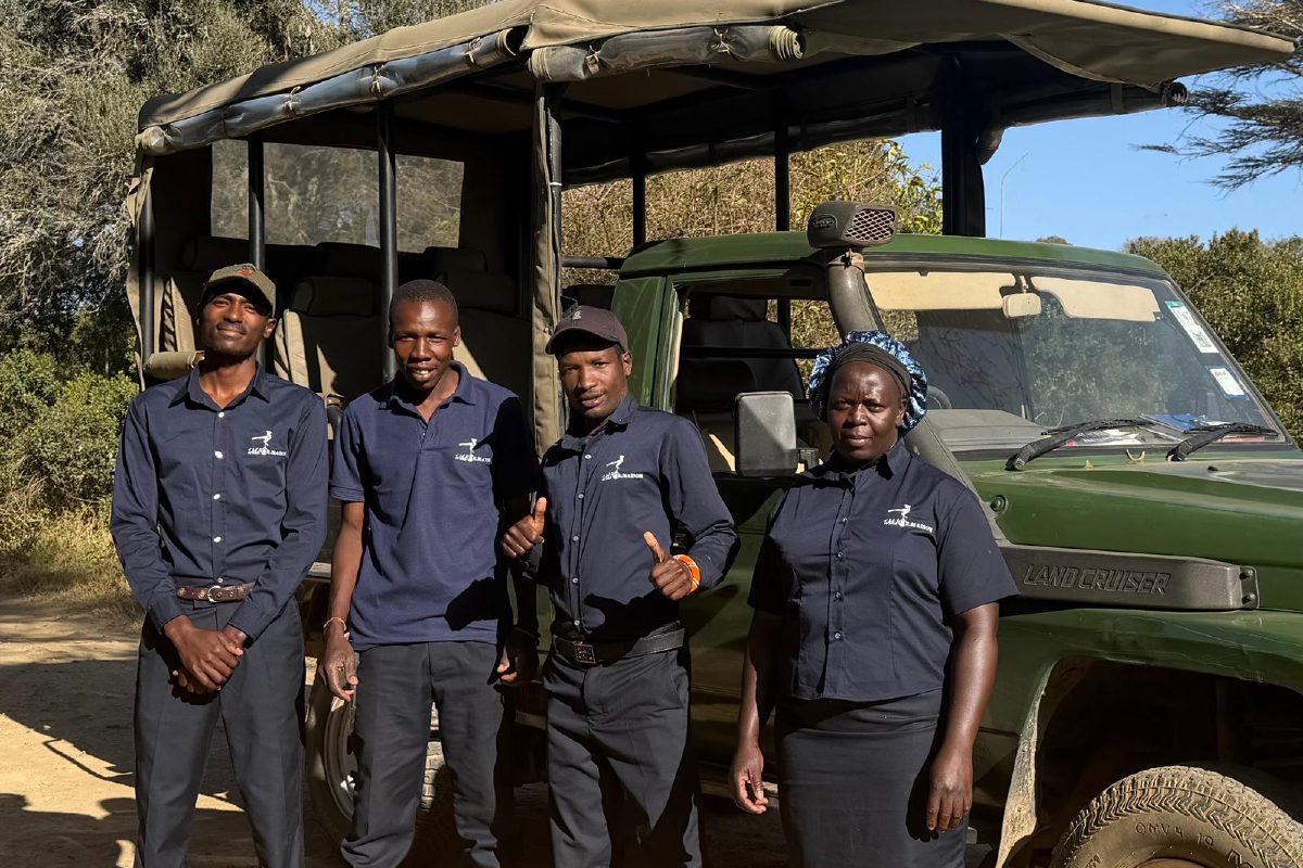 Richard, Mwangi, Nick and Regina standing beside an Ol Maisor safari vehicle.